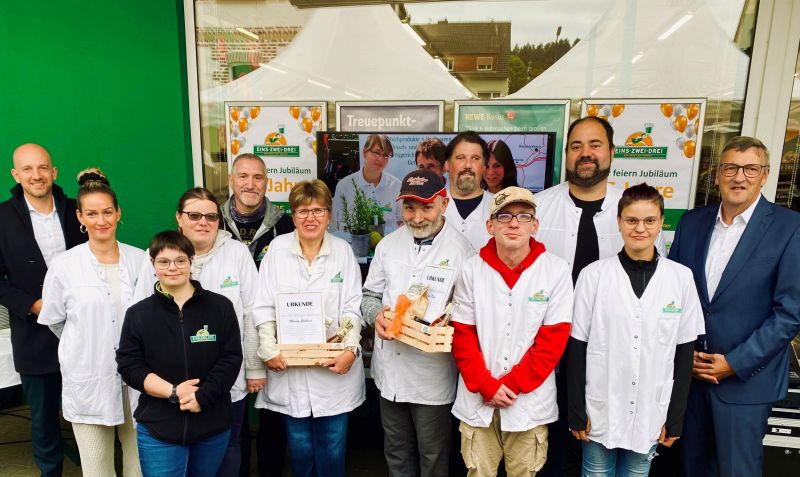 Foto: Mit den Dienstjubilaren Mandy Goldbach und Stefan Neff (Mitte) freuen sich das Team des 1-2-3-Markts in Bad Soden Salmünster sowie Geschäftsführer Martin Berg (rechts) und Bürgermeister Dominik Brasch (links).